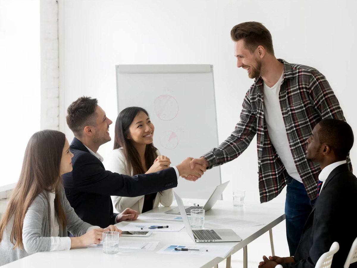 Sales colleagues celebrating a closed deal at their desk