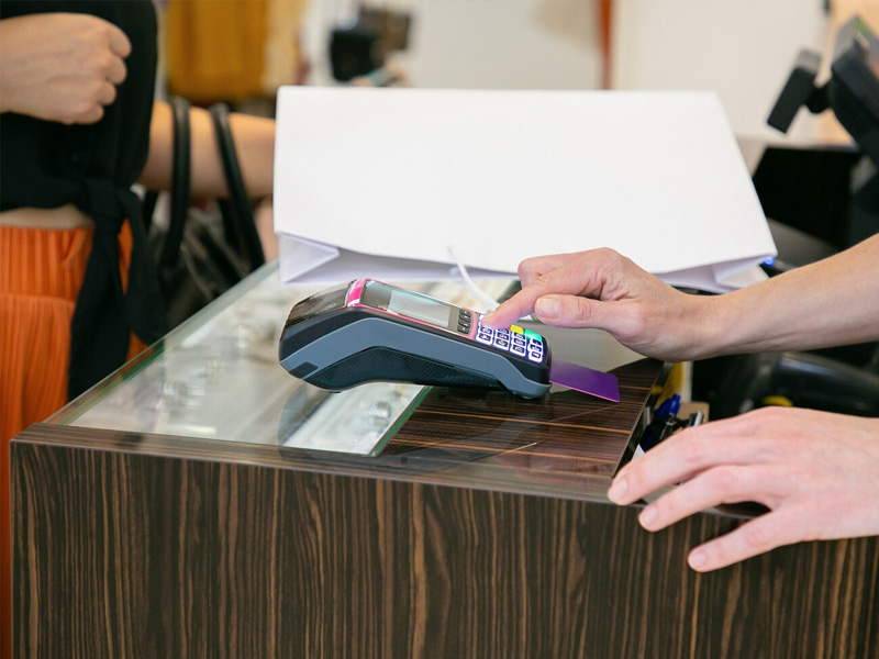 A customer paying by phone at a shop counter